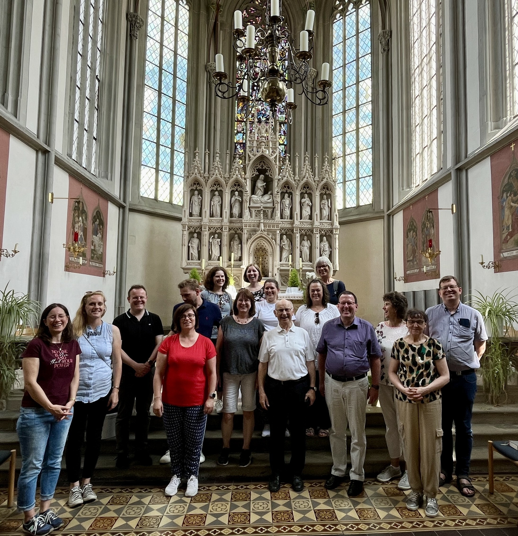 Vor dem Hochaltar im Chor der Ritterkapelle stellten sich die Seelsorger und Mitarbeiter  des Pastoralen Teams Würzburg Nord-West mit dem Kirchenführer Albin Schorn zum Gruppenfoto.